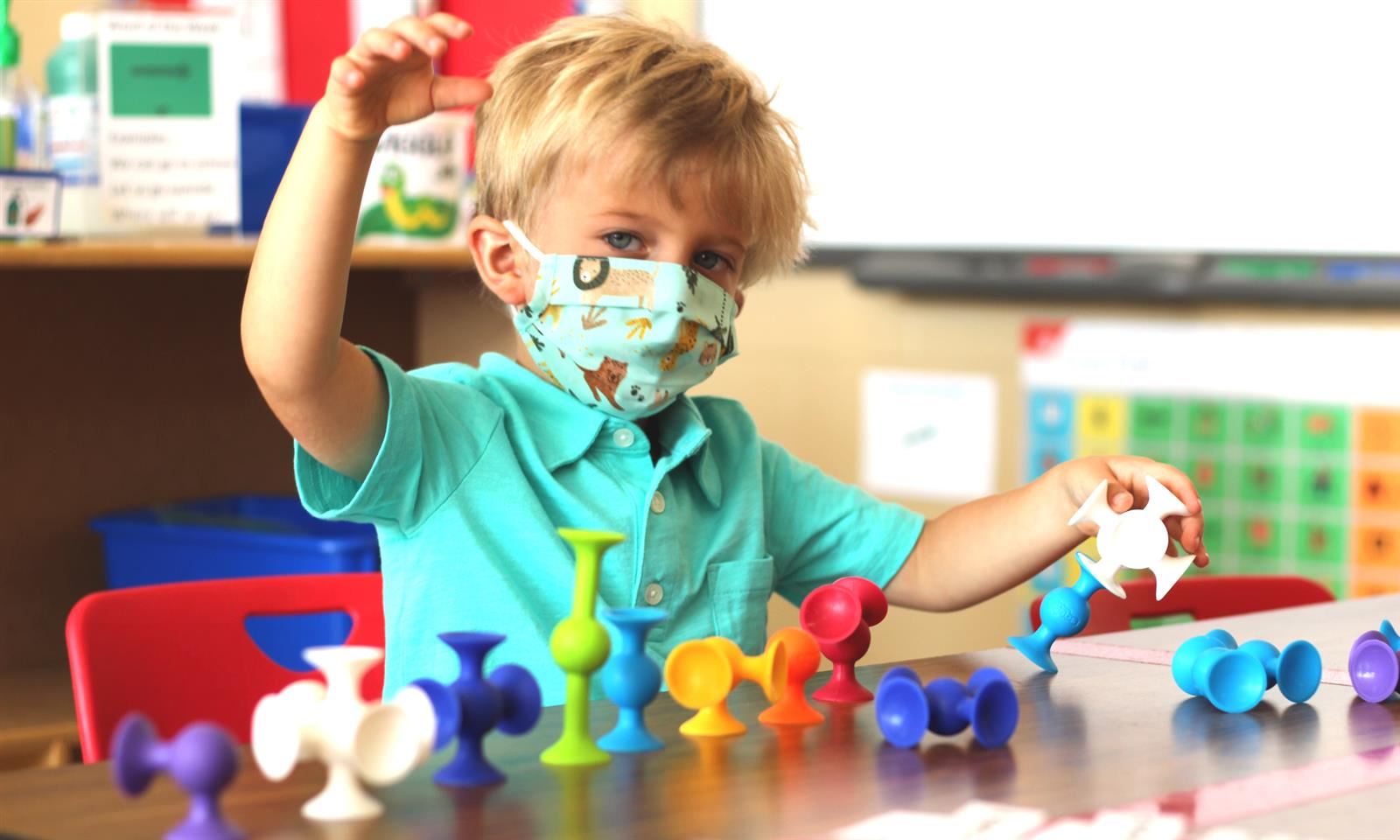A child plays with toys on a table
